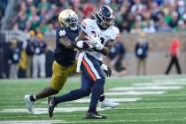 Virginia wide receiver Joe Reed (2) runs after making a catch in front of Notre Dame linebacker ...