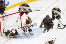 Golden Knights' William Karlsson (71) jumps out of the way of the puck as Boston Bruins goalten ...