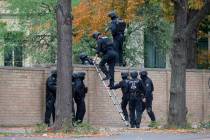 Police officers cross a wall at a crime scene in Halle, Germany, Wednesday, Oct. 9, 2019 after ...