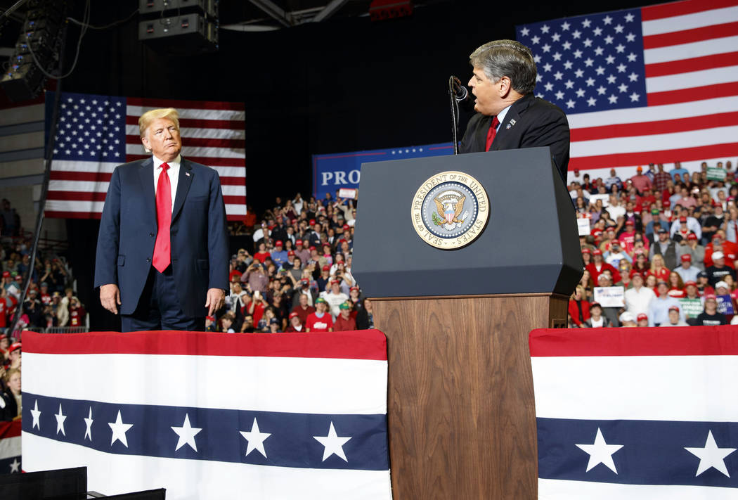 President Donald Trump listens Fox News' Sean Hannity speak during a rally. (AP Photo/Carolyn K ...