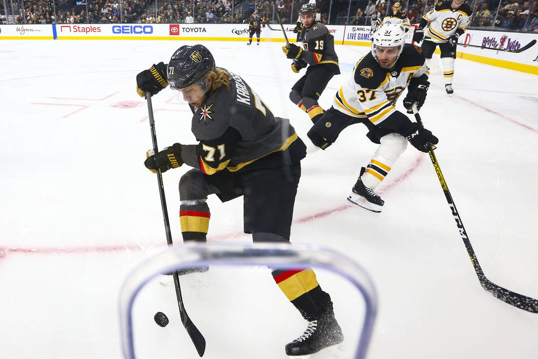 Golden Knights' William Karlsson (71) moves the puck in front of Boston Bruins' Patrice Bergero ...