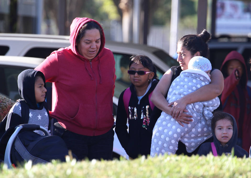 Parents and children are bundled up as they wait for the school bus at West Viking Road in Las ...