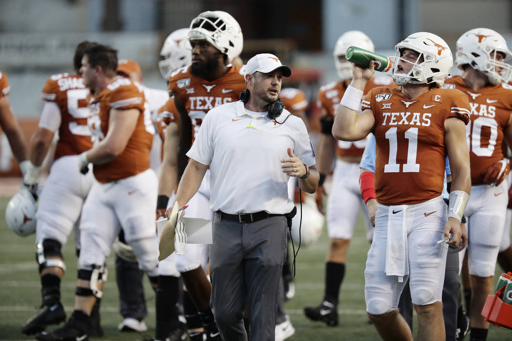 Texas head coach Tom Herman, center, and Texas quarterback Sam Ehlinger (11) during the first h ...