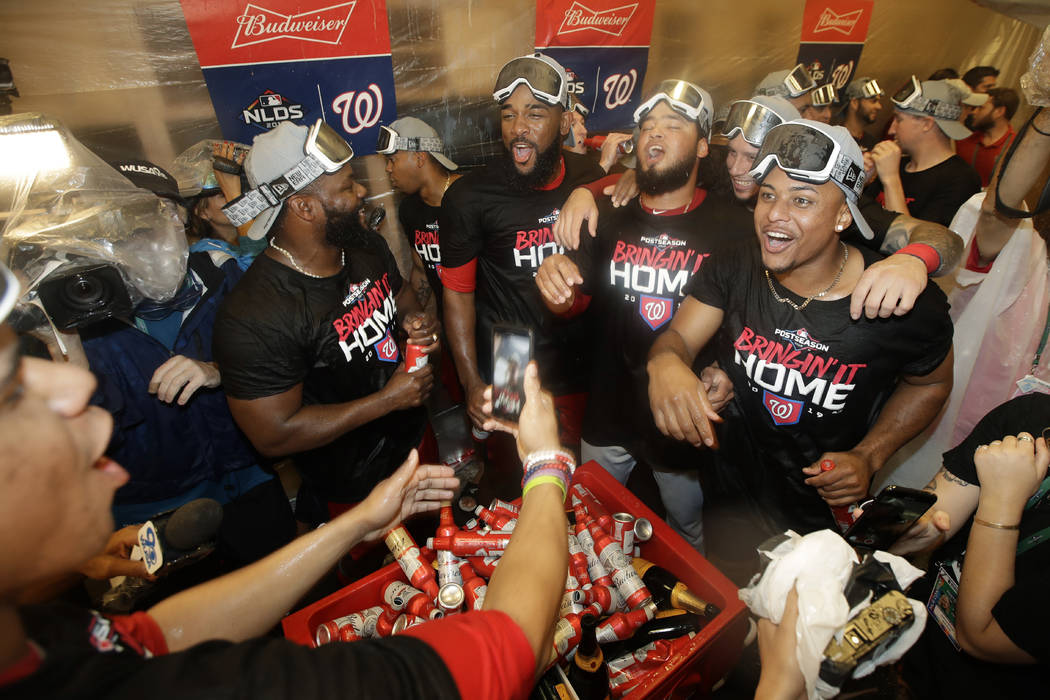 Washington Nationals celebrate in the locker room after their 7-3 win in 10 innings against the ...