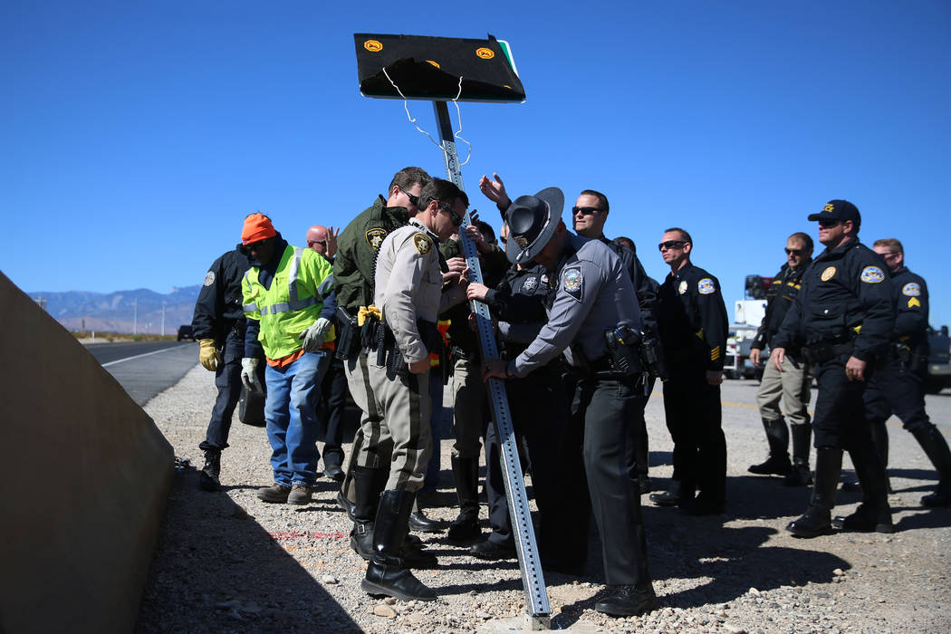 Multi-agency law enforcement officers assist in installing the DUI Victim Memorial Sign during ...