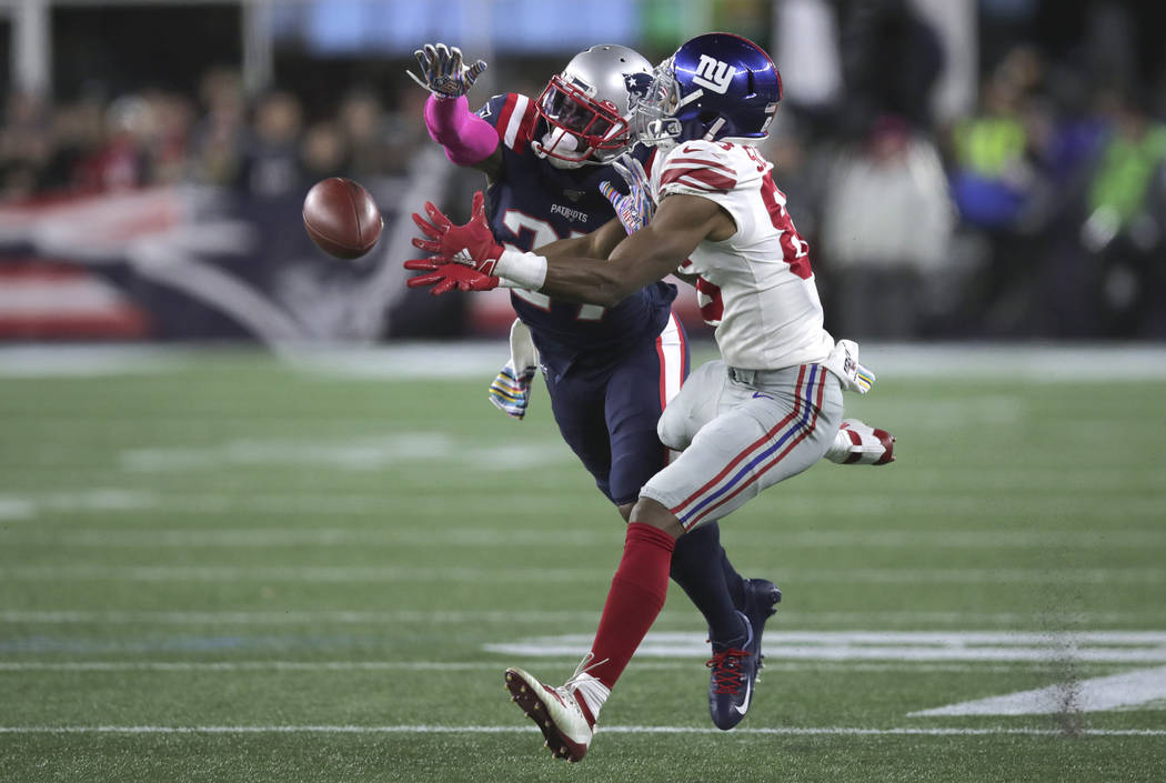 New England Patriots defensive back J.C. Jackson, left, breaks up a pass intended for New York ...