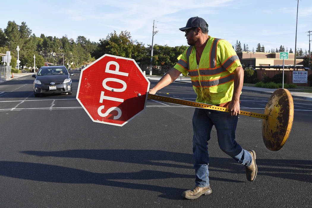 A Moraga city works crew member removes a temporary stop sign at the corner of Moraga Way and S ...