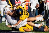 West Virginia linebacker Dylan Tonkery (10) tackles Texas quarterback Sam Ehlinger, left, who c ...