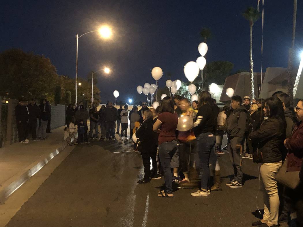 Nearly a hundred mourners gathered on Friday, Oct. 11, 2019, outside the Viridian Apartments, 4 ...