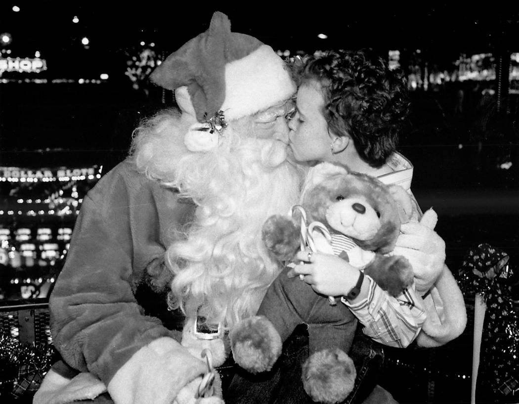 Carrie Maness, 9, of Forest Virginia, plants a kiss on Santa's nose on the midway at Circus Cir ...
