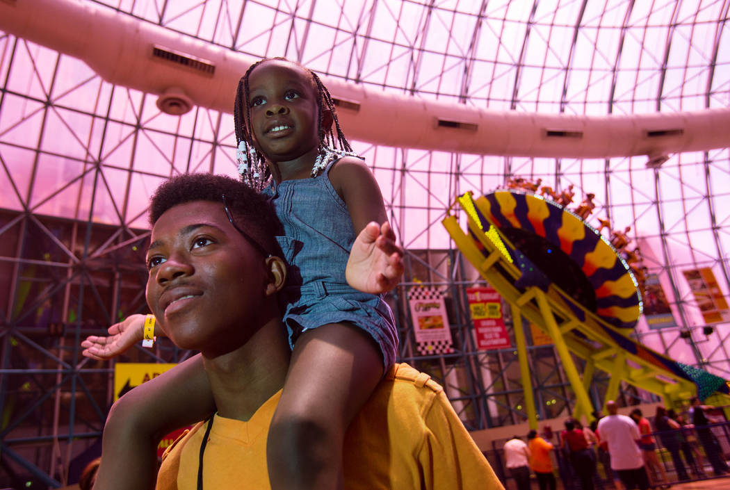 Pierre Cooley, 18, and his niece, Jasmine Driver, 3, watch a magic show at the Adventuredome Th ...