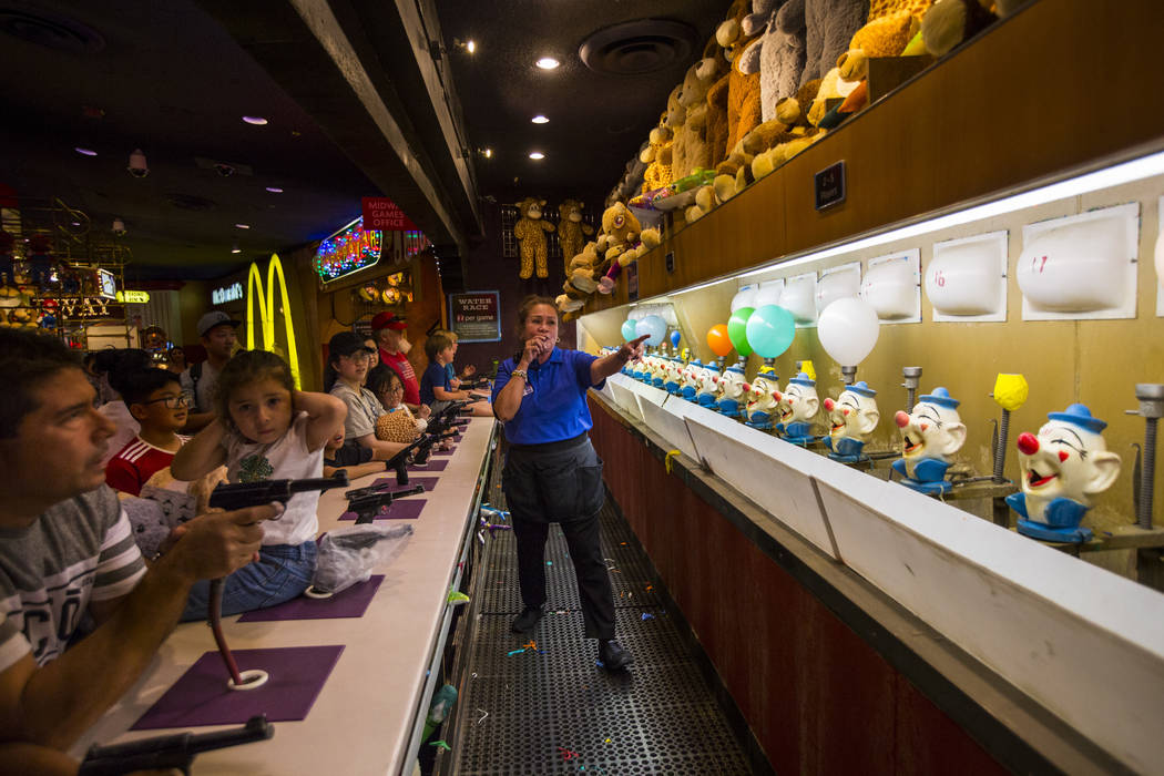 Game attendant Dulcesima gives directions to competitors at the carnival midway at Circus Circu ...