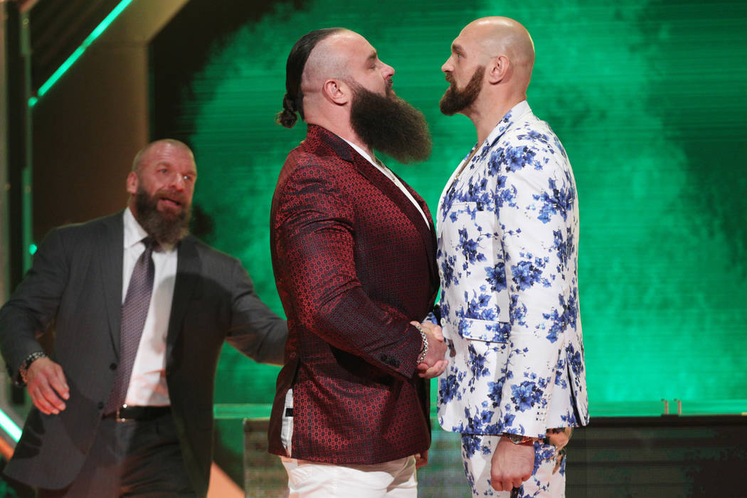 Paul Levesque, left, better known as Triple H, looks on as Braun Strowman, center, and Tyson Fu ...