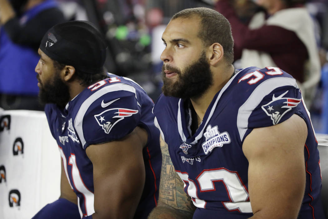 New England Patriots defensive tackle Lawrence Guy, right, watches from the bench with defensiv ...