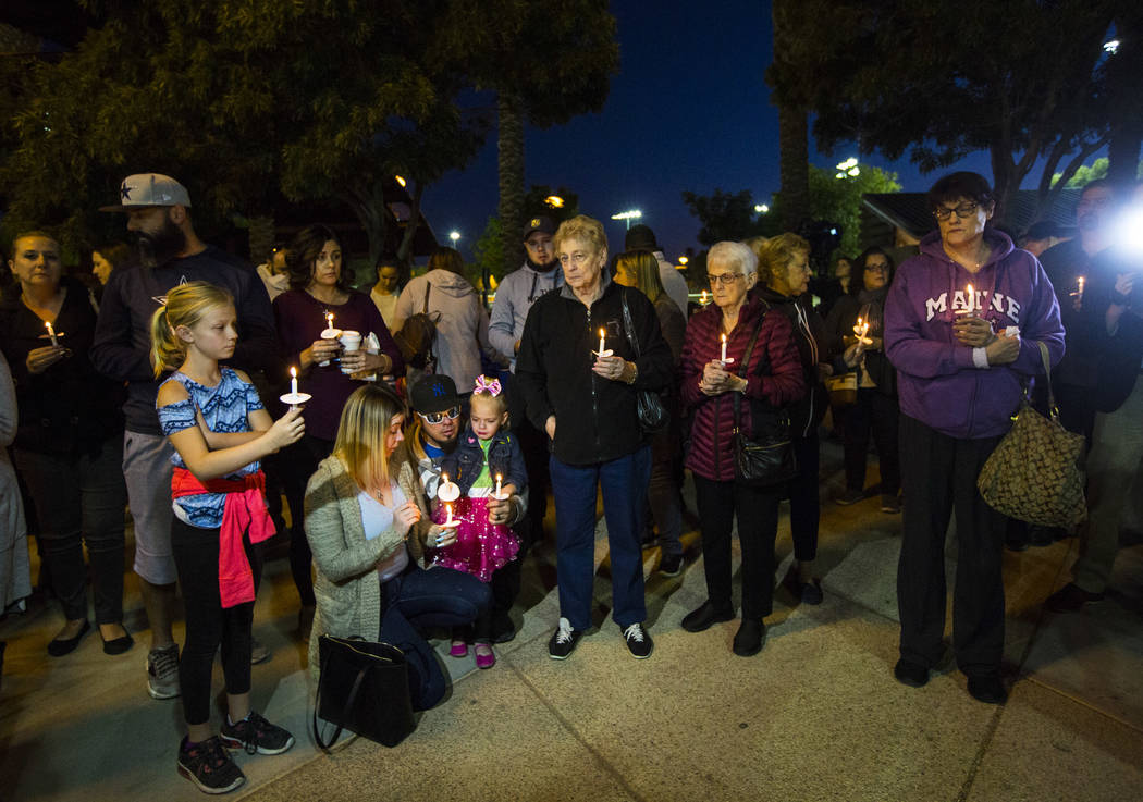 People hold candles in memory of Gavin Murray Palmer, who was lost in a house fire, during a ca ...