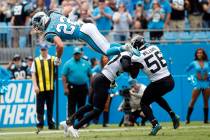 Carolina Panthers running back Christian McCaffrey (22) jumps over Jacksonville Jaguars cornerb ...