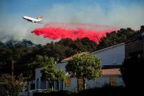 An air tanker drops retardant behind the Newhall Church of the Nazarene while battling the Sadd ...