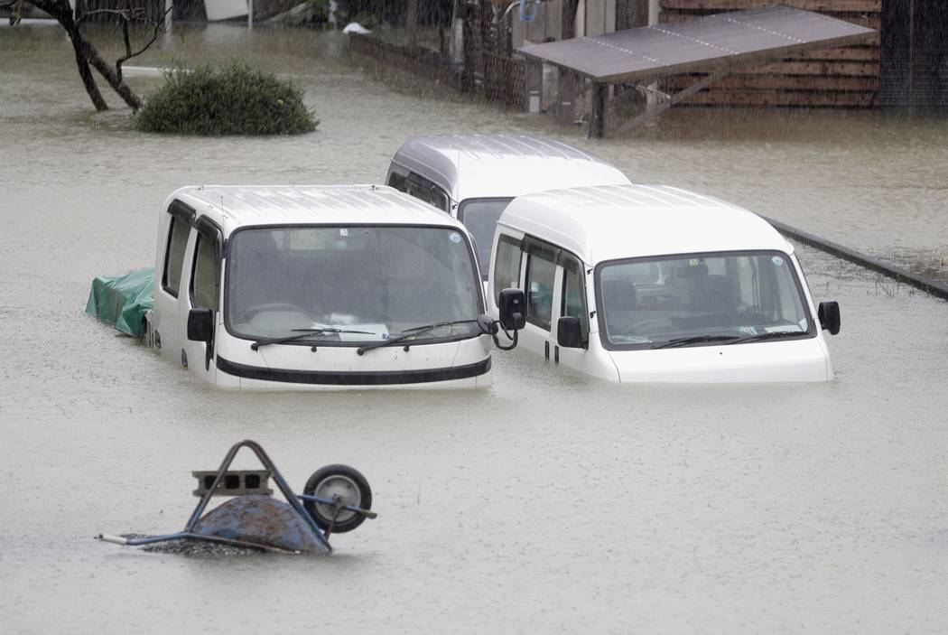 Cars sit submerged in water in the residential area hit by Typhoon Hagibis, in Ise, central Jap ...
