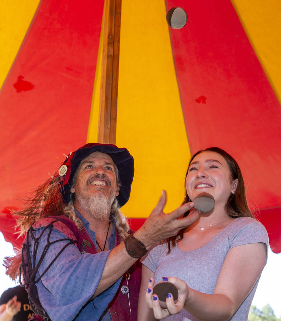 Juggler Adam Reid of Bawdy Juggling teaches Charlotte Pianko how to toss three balls at once du ...