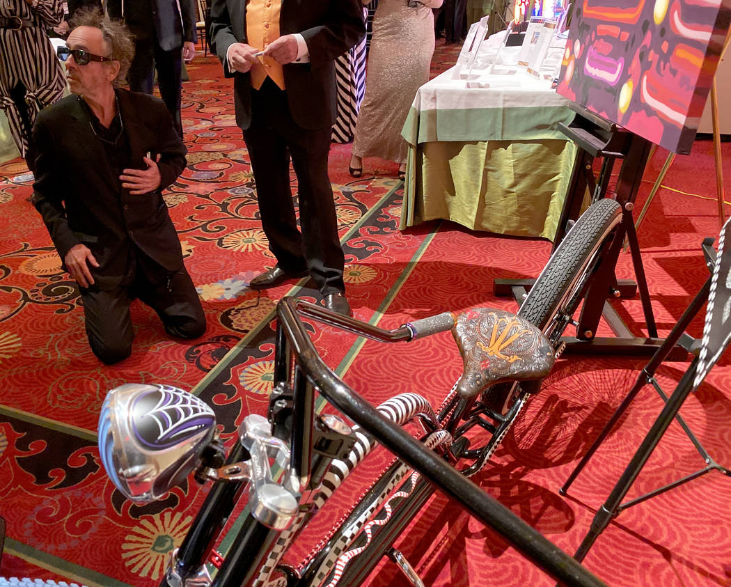 Tim Burton signs a custom bicycle by Brad Marlon up for auction during cocktail hour at The Neo ...