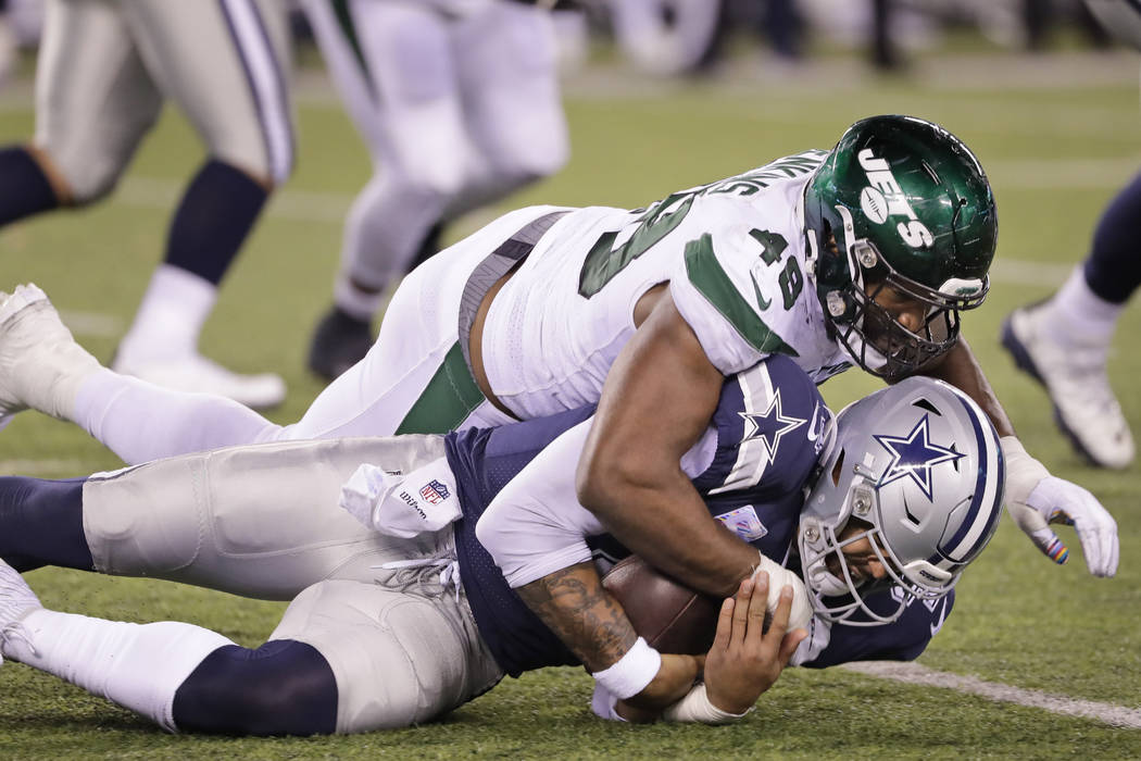 New York Jets' Jordan Jenkins, top, takes down Dallas Cowboys quarterback Dak Prescott during t ...