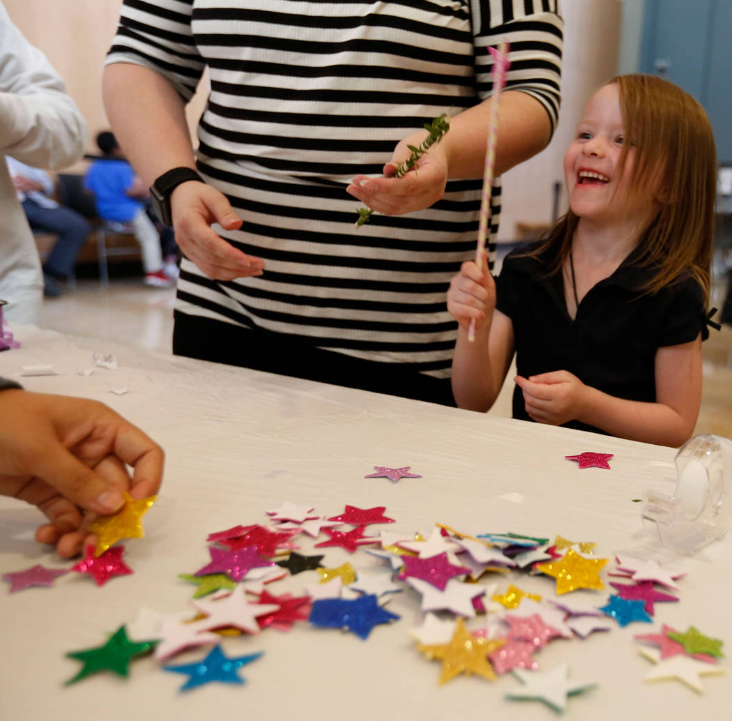 Haylee Applegate, 5, of Las Vegas makes a wand with her mother Ashley Brookins during Mystic Fa ...