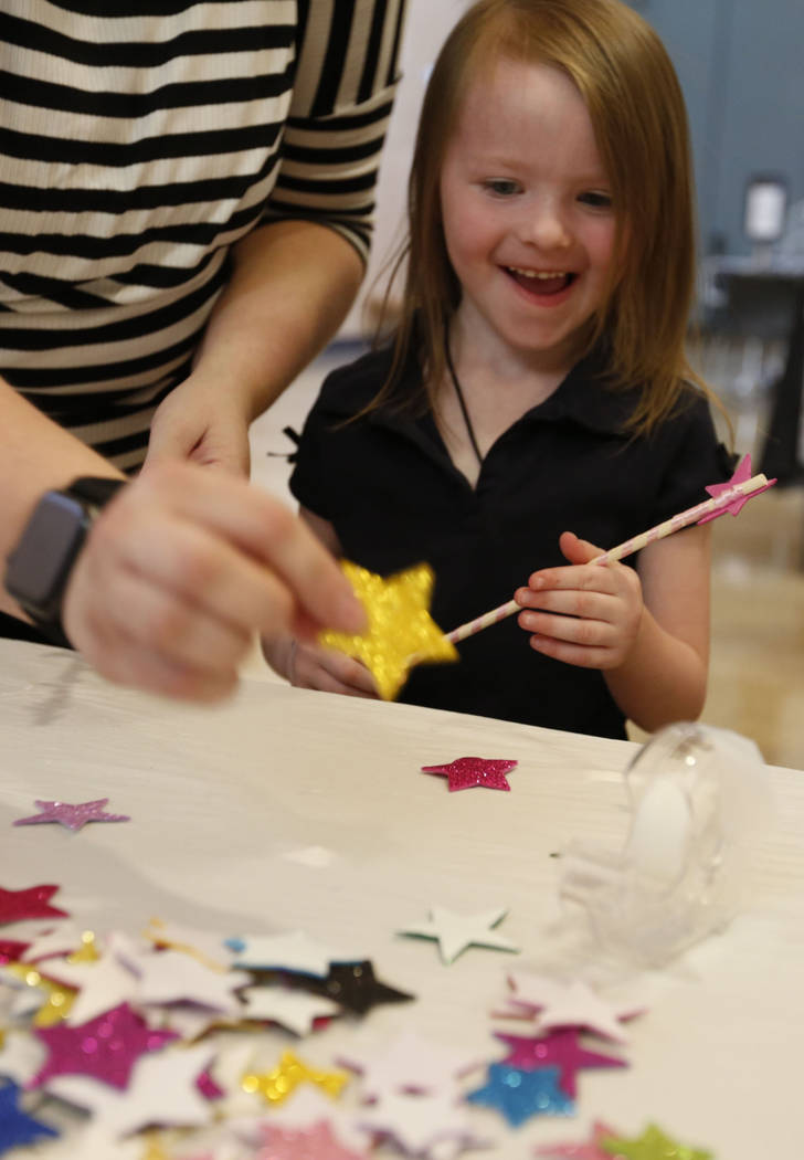 Haylee Applegate, 5, of Las Vegas makes a wand with her mother Ashley Brookins during Mystic Fa ...