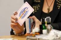 Local psychic Nicole Borghi shows a card during her angel card reading session with her client ...