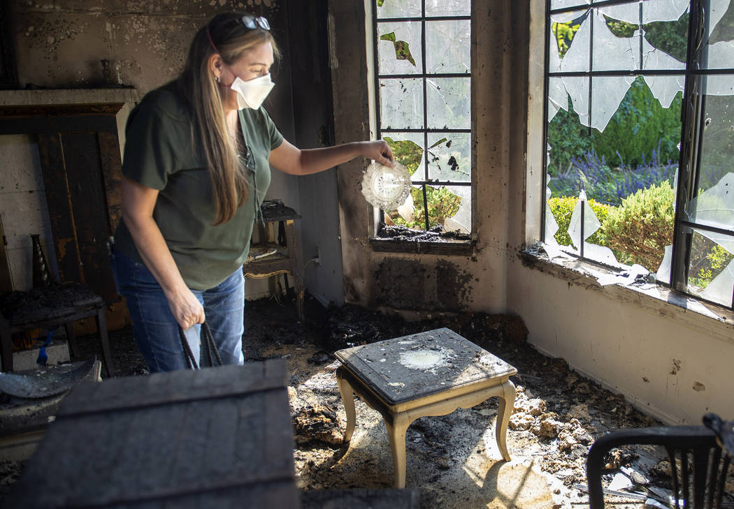 Loretta Reel picks up a doily that managed to survive a fire that destroyed her in-laws home in ...
