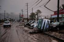 Typhoon-damaged cars sit on the street covered with mud Monday, Oct. 14, 2019, in Hoyasu, Japan ...