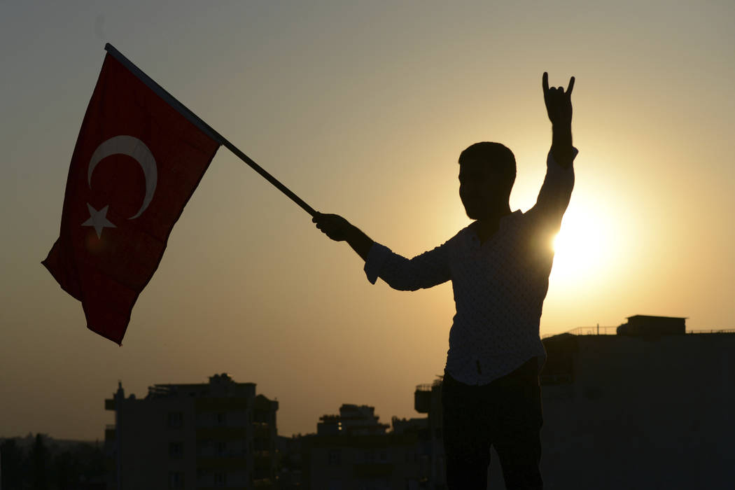 A Turkish youth celebrates with a national flag after news about Syrian town of Tal Abyad, in T ...