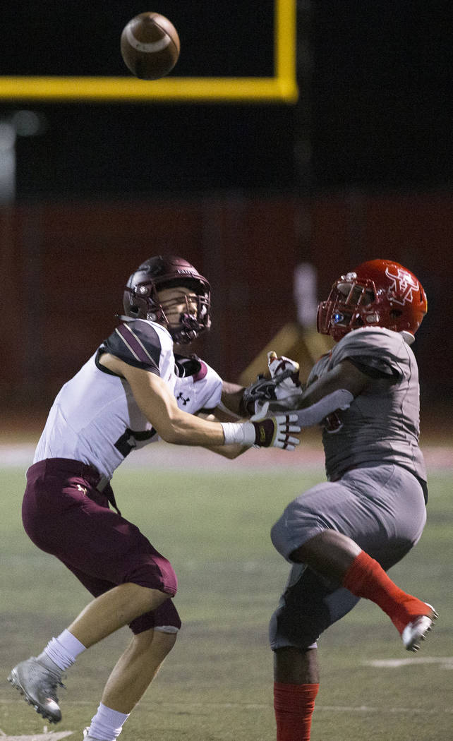 Faith Lutheran senior wide receiver Riley Schwartz (2) fights for a deflected pass with Arbor V ...