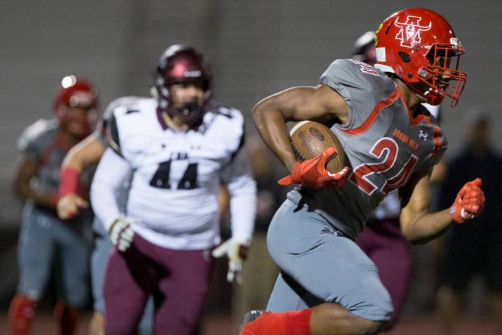 Arbor View senior running back Daniel Mitchell (24) breaks a big run past Faith Lutheran junior ...