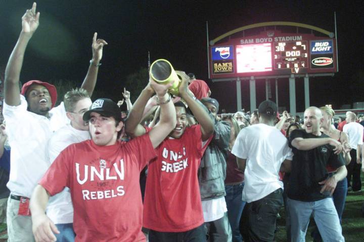 Sports; 10-07-00, UNLV football fans carry a piece of the goal post after the Rebels beat UNR. ...