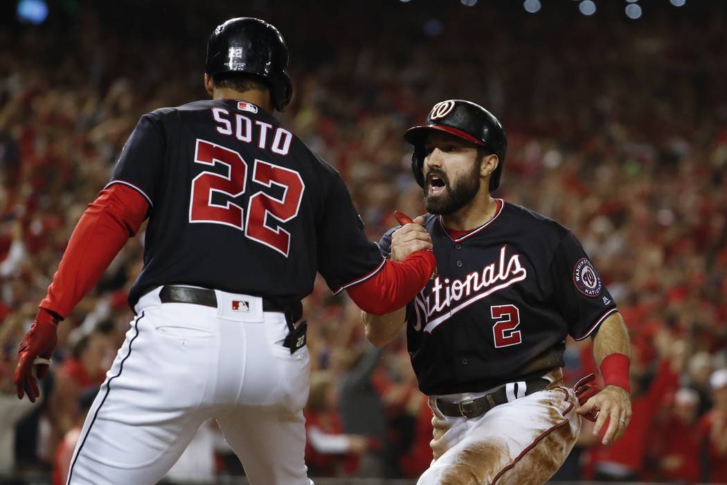 Washington Nationals' Adam Eaton celebrates with Juan Soto (22) after scoring on a hit by -Anth ...
