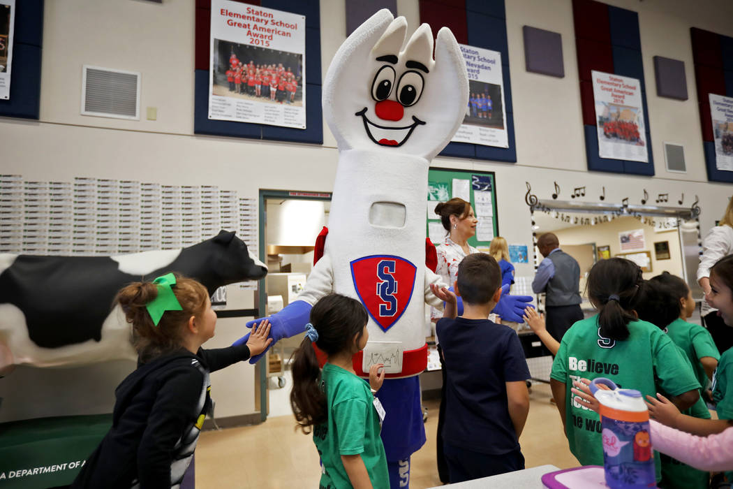 Clark County School District food services mascot Sporky high-fives students at Staton Elementa ...