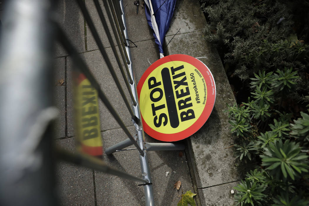 A stop Brexit placard lies across the street from the Houses of Parliament in London, Tuesday, ...