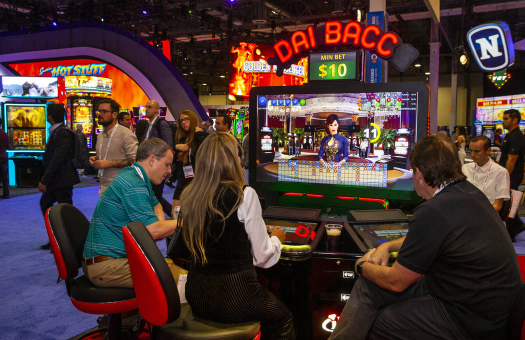 Attendees play the new Dai Bacc automated electronic table game by Interblock during the Global ...