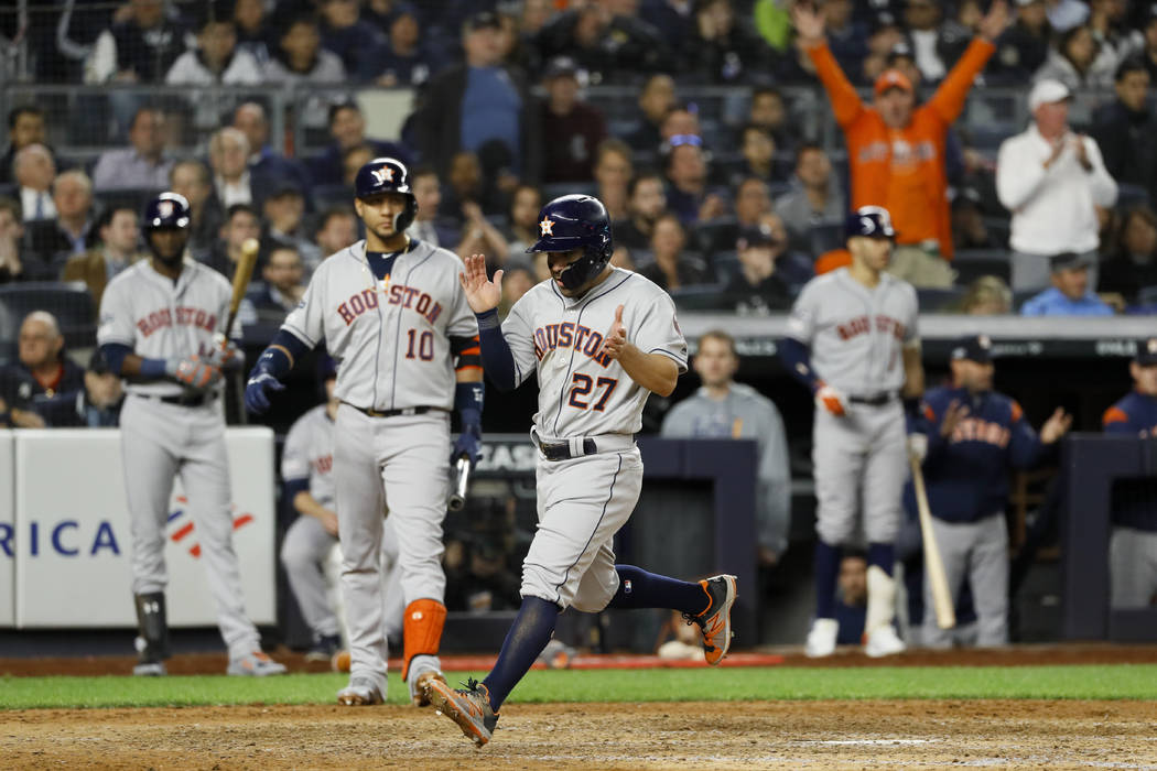 Houston Astros' Jose Altuve celebrates after scoring on a wild pitch during the seventh inning ...