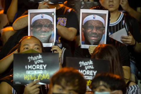 Demonstrators hold up photos of LeBron James grimacing during a rally at the Southorn Playgroun ...