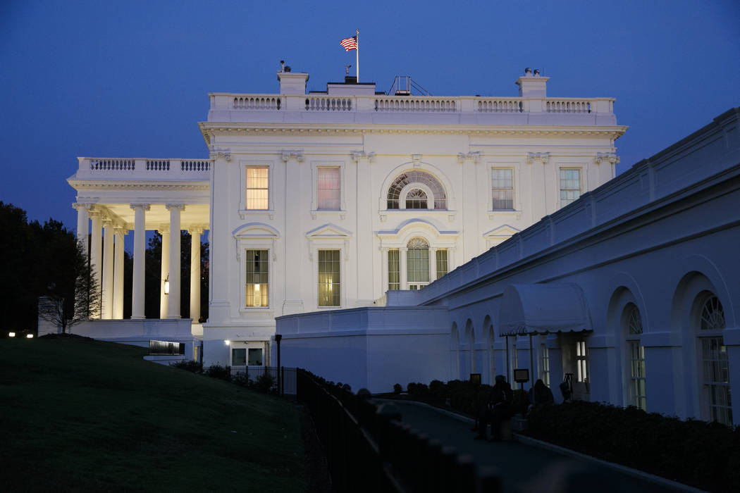 The White House is seen at dusk as members of the media wait for comment from Charlotte Charles ...