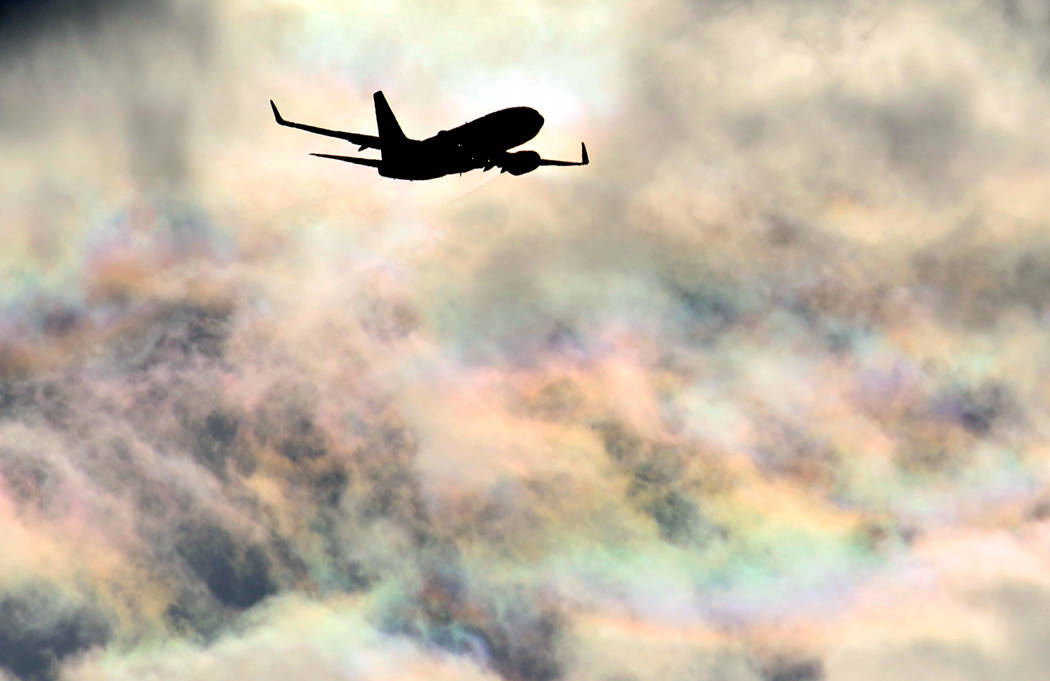 A Southwest Airlines plane flies under rainbow sky as it approaches McCarran International Airp ...