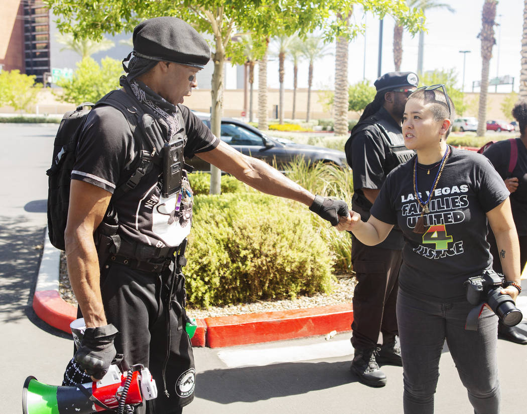Jay Jackson, local chairman of the New Black Panther Party, left, fist bumps Nissa Tzun, right, ...