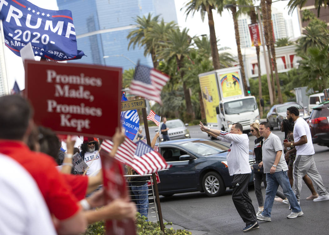 Passersby cheer on Trump supporters as they occupy an intersection of the Las Vegas Strip on Th ...