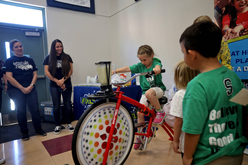 Isabella Duren, 5, peddles a bike that powers a blender to make a smoothie at Staton Elementary ...