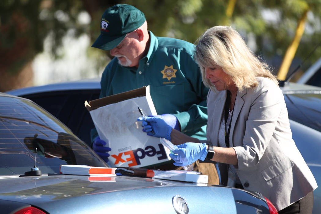 Las Vegas police homicide cold case investigators Dan Long, left, and Terri Miller collect DNA ...