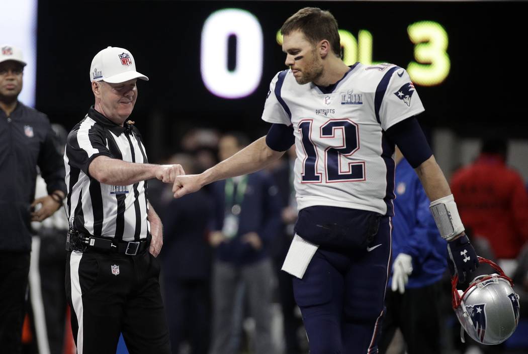 Referee John Parry, left, bumps fists with New England Patriots' Tom Brady before the NFL Super ...