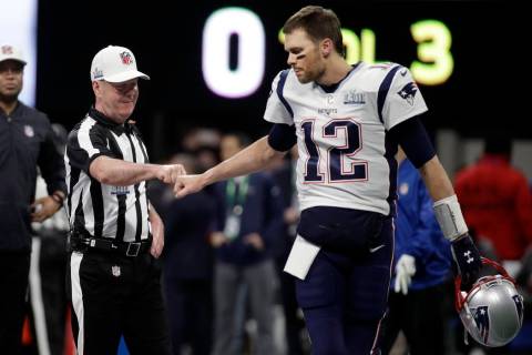 Referee John Parry, left, bumps fists with New England Patriots' Tom Brady before the NFL Super ...