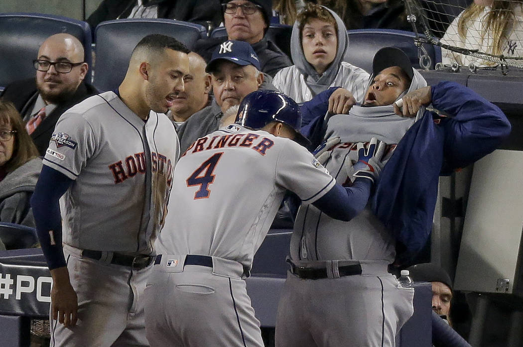 Houston Astros' George Springer (4) celebrates with Martin Maldonado, right, and Carlos Correa ...
