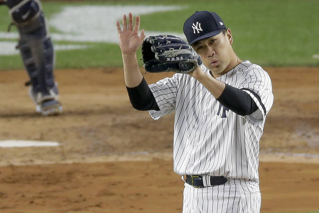 New York Yankees starting pitcher Masahiro Tanaka reacts as right fielder Aaron Judge makes a d ...